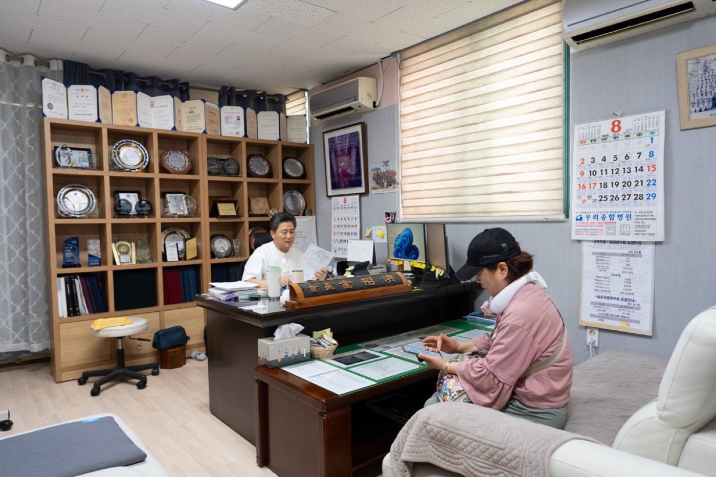 창가 쪽 상담실에서 내방객과 마주 앉아 상담하는 모습